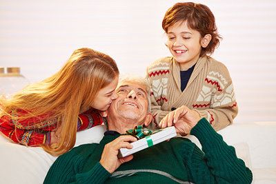 Opa bekommt Weihnachtsgeschenke von seinen Enkeln