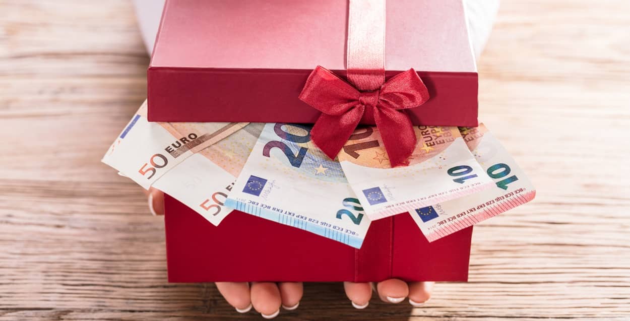 Rotes Geschenkpäckchen mit Geldscheinen als Jugendweihe Geschenk für Jungen