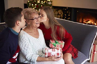 Oma bekommt Weihnachtsgeschenke von ihren Enkeln